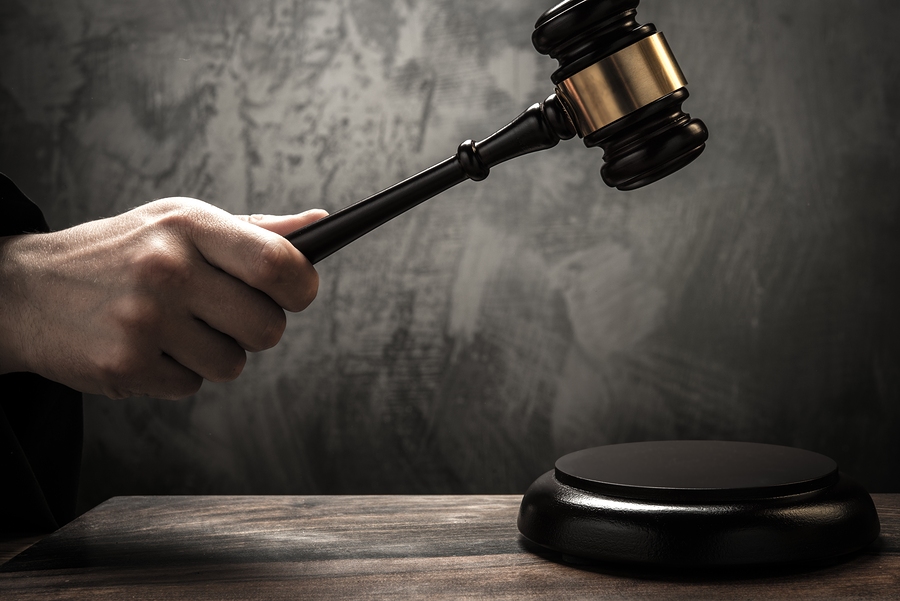 Judge's hand holding wooden hammer Judge's hand holding wooden hammer