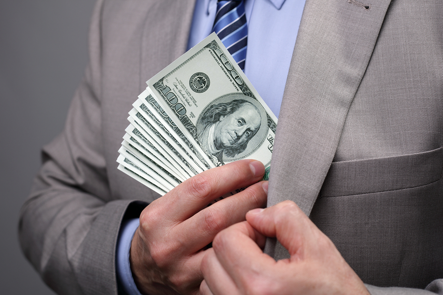 Man putting money in suit jacket pocket concept for corruption,