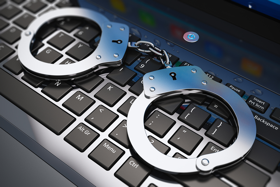 Handcuffs on laptop keyboard Handcuffs on laptop keyboard