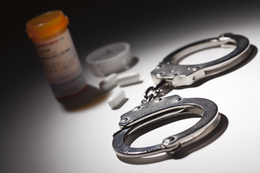 Handcuffs, Medicine Bottle and Pills Under Spot Light Abstract. Handcuffs, Medicine Bottle and Pills Under Spot Light Abstract.