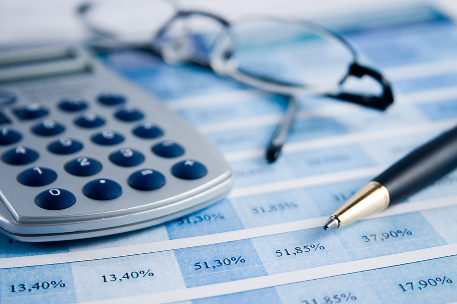 calculator glasses and pen with paperwork