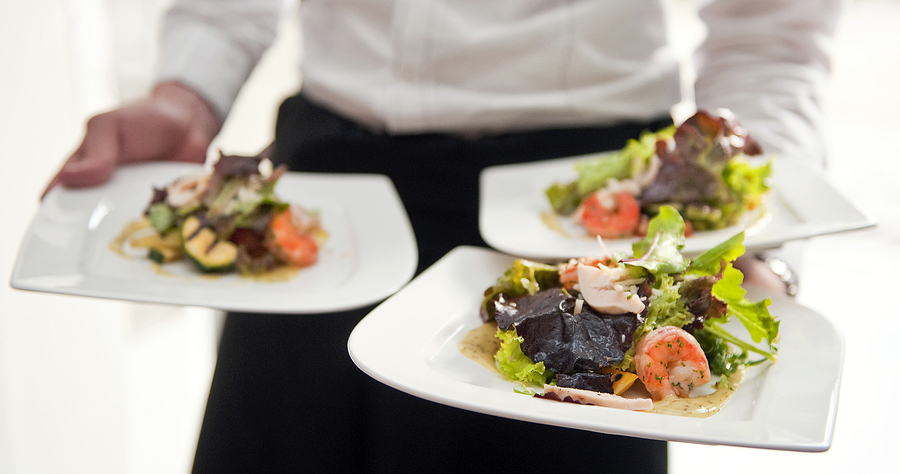 Waiter, carrying three plates with a rich salad Waiter, carrying three plates with a rich salad