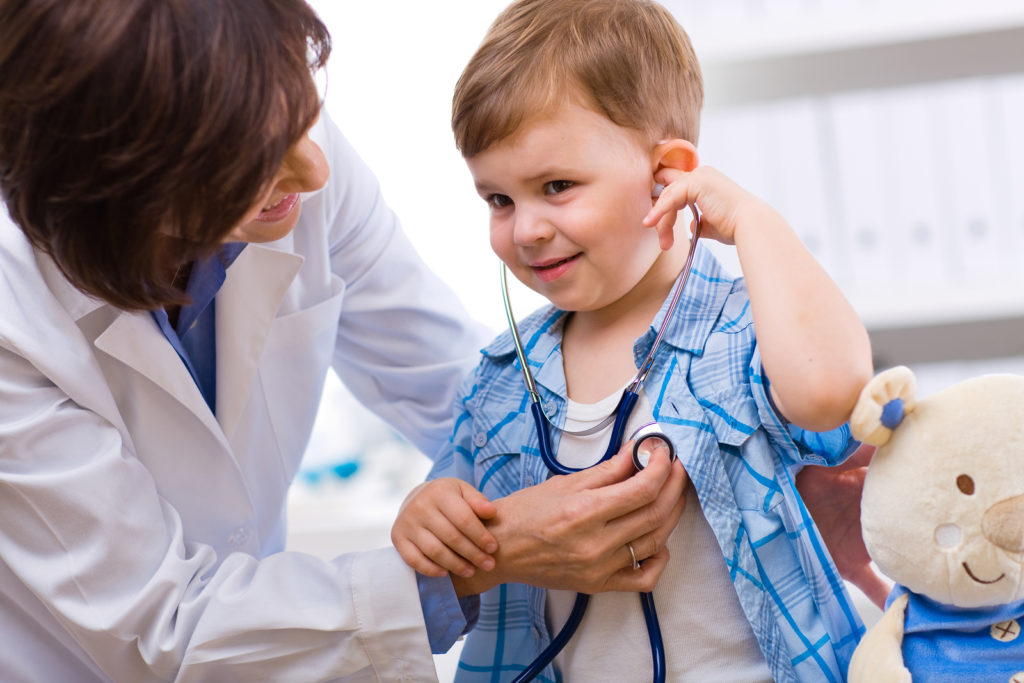 Senior female doctor examining happy child smiling. Senior female doctor examining happy child smiling.