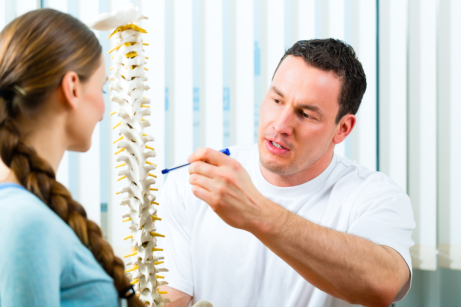 Physiotherapist in his practice, he explains a female patient th